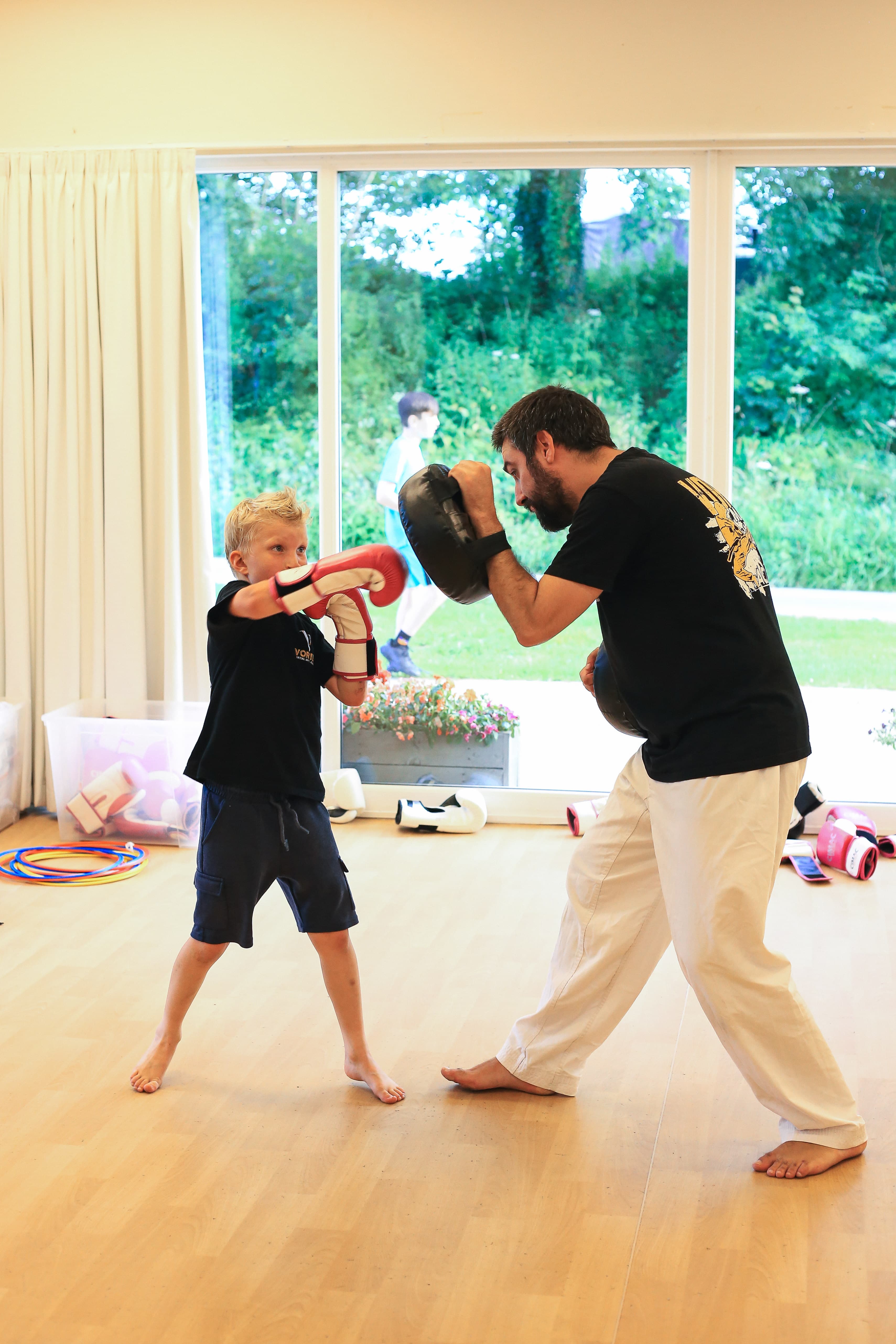Students working pads in a kickboxing class at Vortex Martial Arts Academy