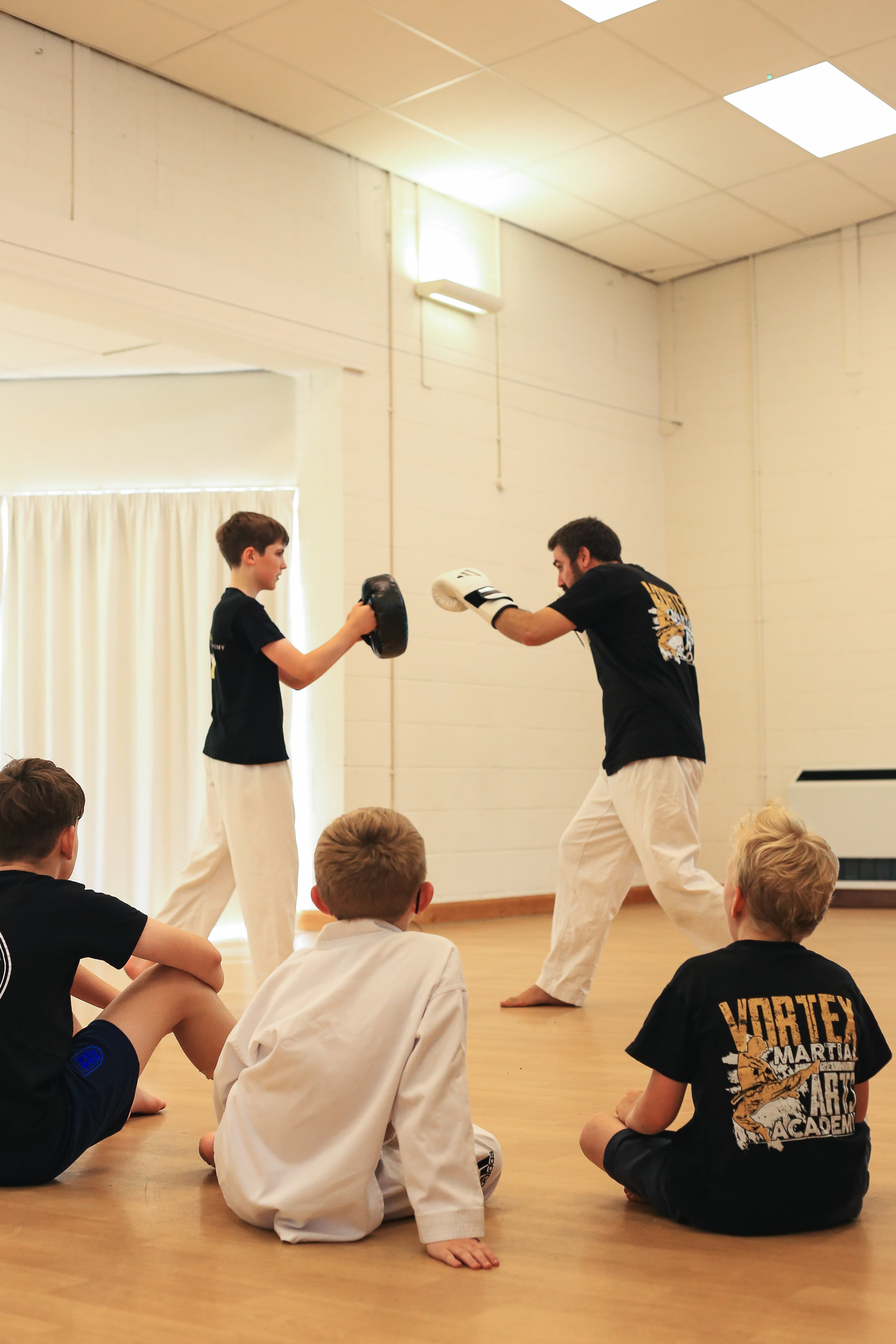 Students drilling kickboxing technique at Vortex Martial Arts Academy